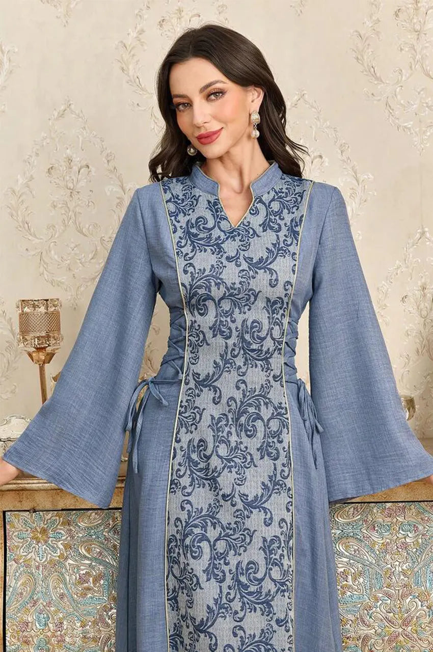 Close-up of the Lumis light blue kaftan V-neckline and intricate blue and white scroll print.