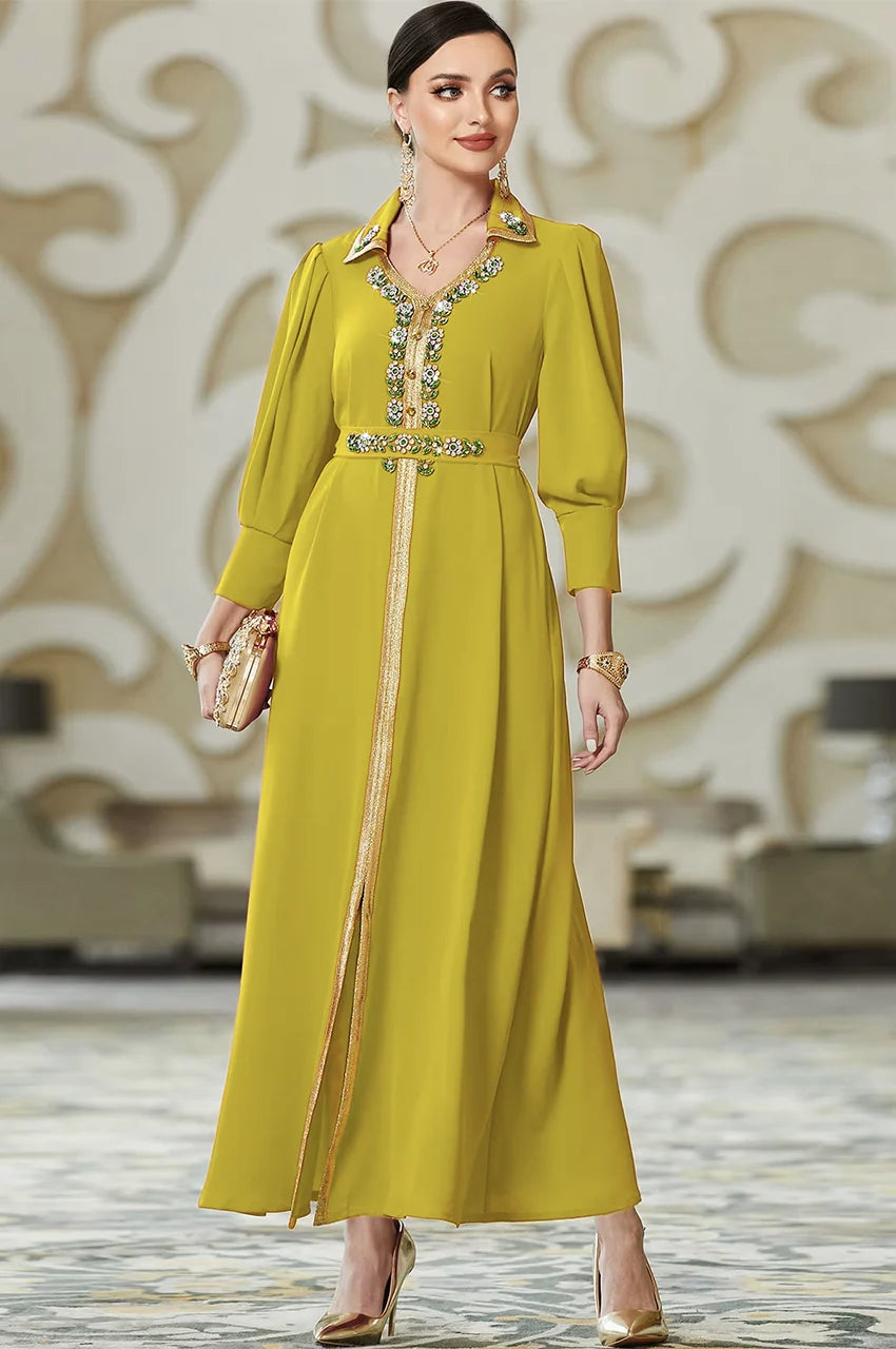 Elegant green Moroccan kaftan styled with a gold clutch and matching belt, showcasing the premium crepe fabric drape.
