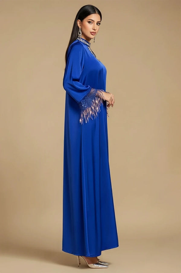 Side profile of blue fringed kaftan with statement feather sleeves