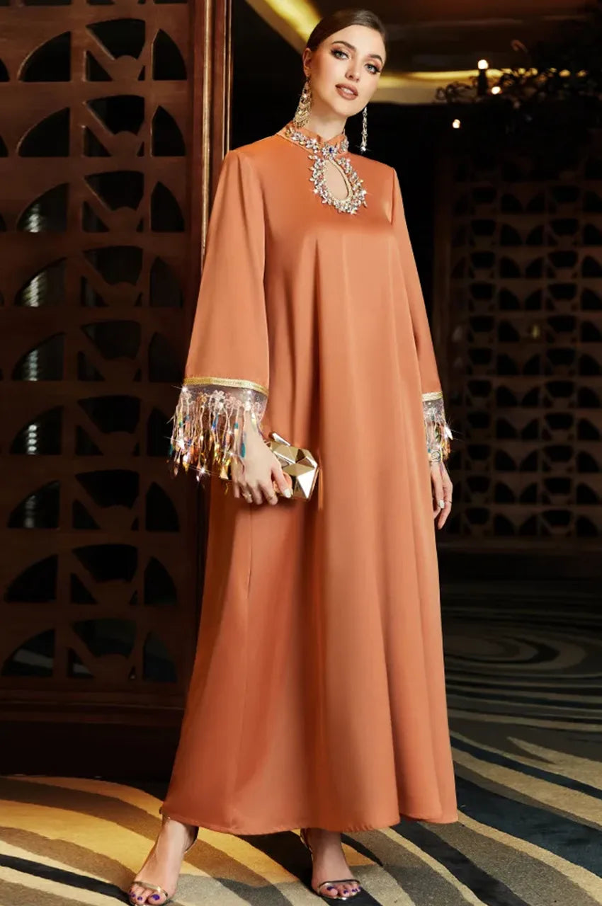 Side pose wearing Luzia orange fringed kaftan with crystal sleeves