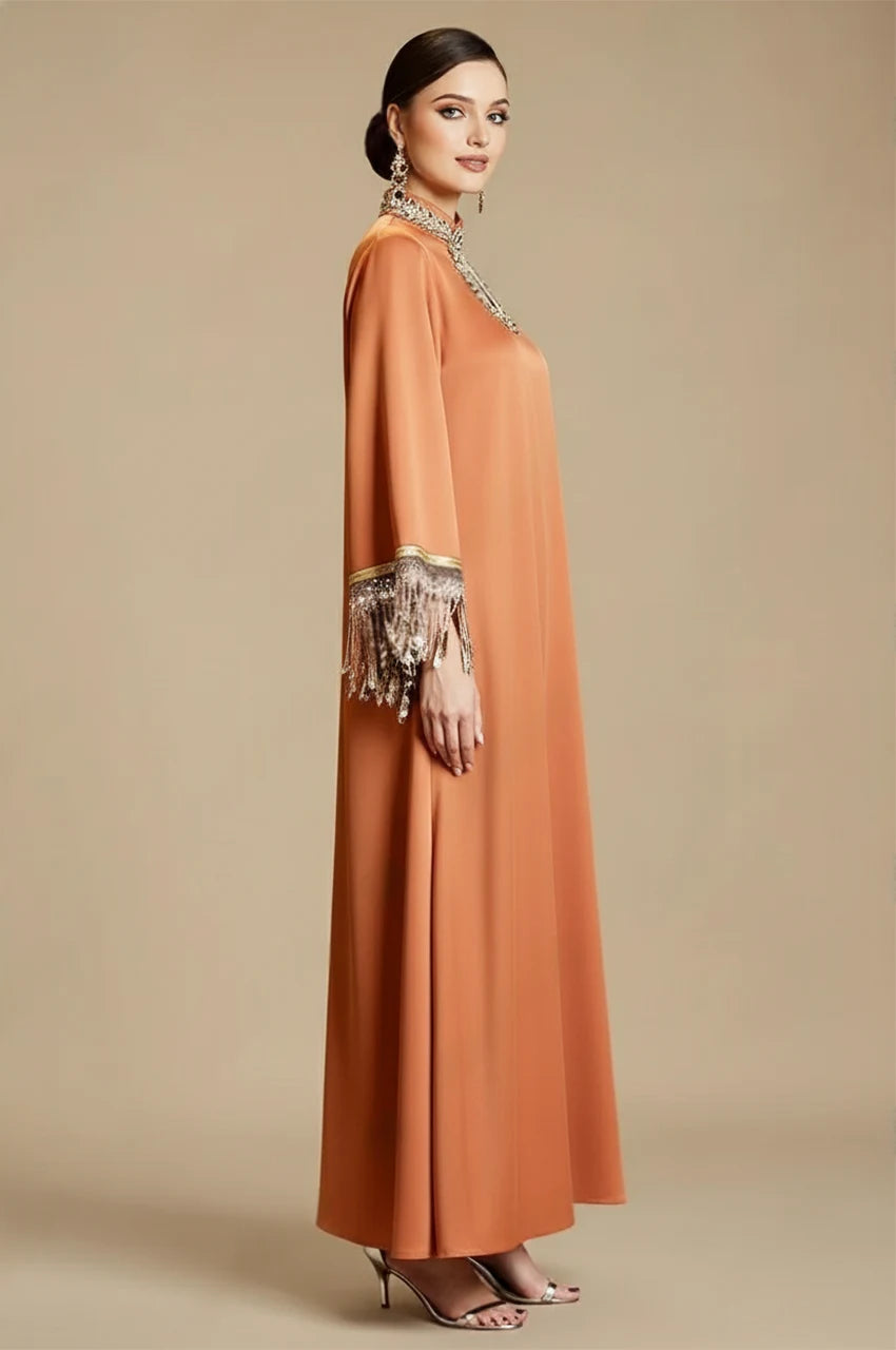 Side view of Luzia Orange Fringed Kaftan showing flowing satin silhouette and embellished fringe cuffs
