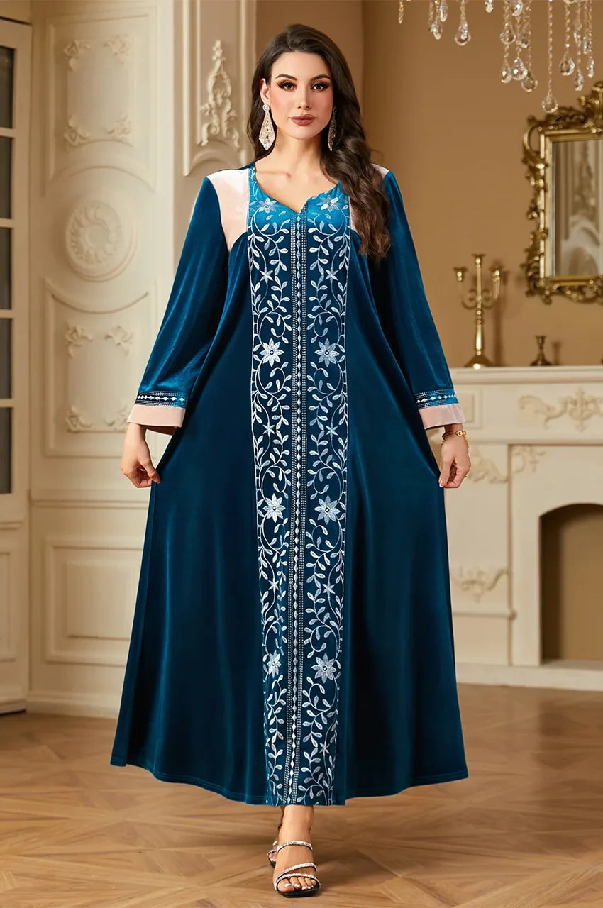 Elegant pose in Lylah blue kaftan showing V-neck and shoulder details.