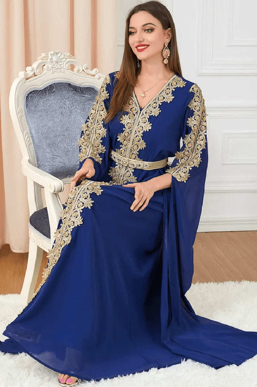 Seated model wearing Maelis navy blue Moroccan traditional kaftan with gold details