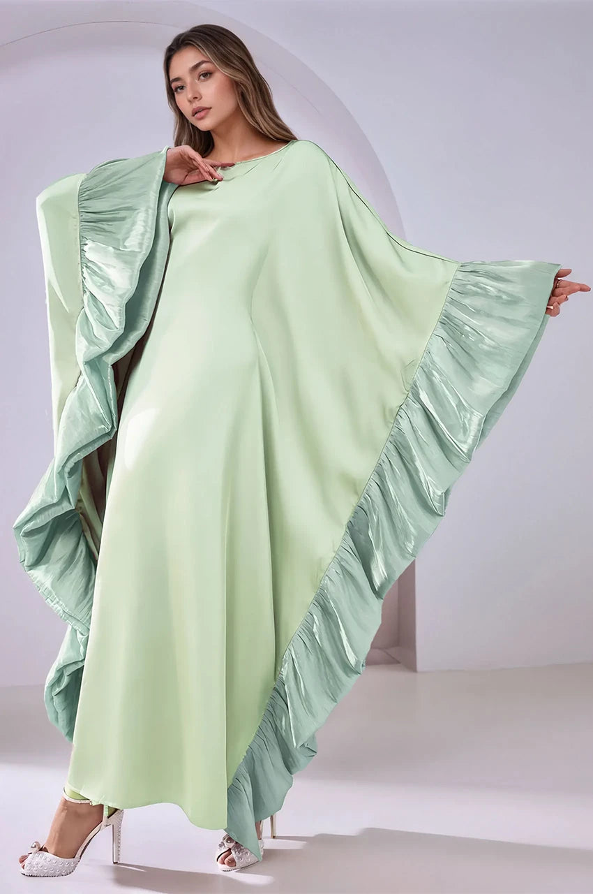 Elegant wide-sleeve pose showcasing the Malya green ruffle kaftan and its cascading ruffle trim