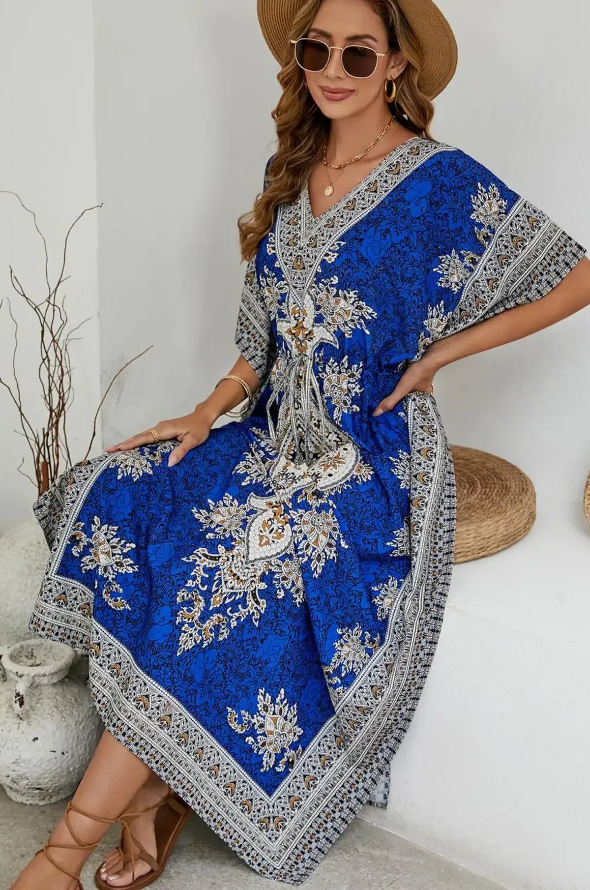 Woman seated in royal blue mandala print maxi kaftan at resort