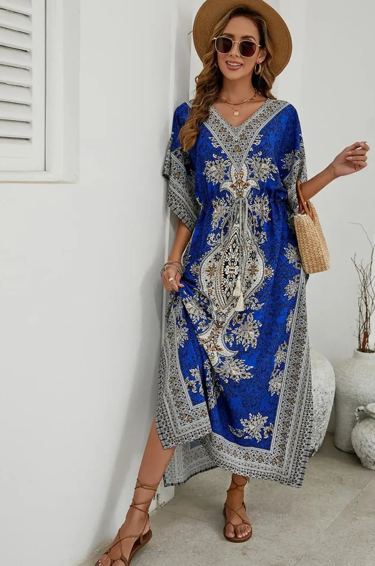 Royal blue mandala kaftan with tassel waist tie leaning against white wall