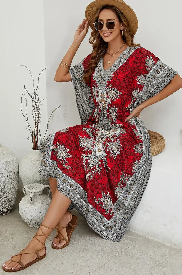Woman seated in crimson mandala print maxi kaftan at resort