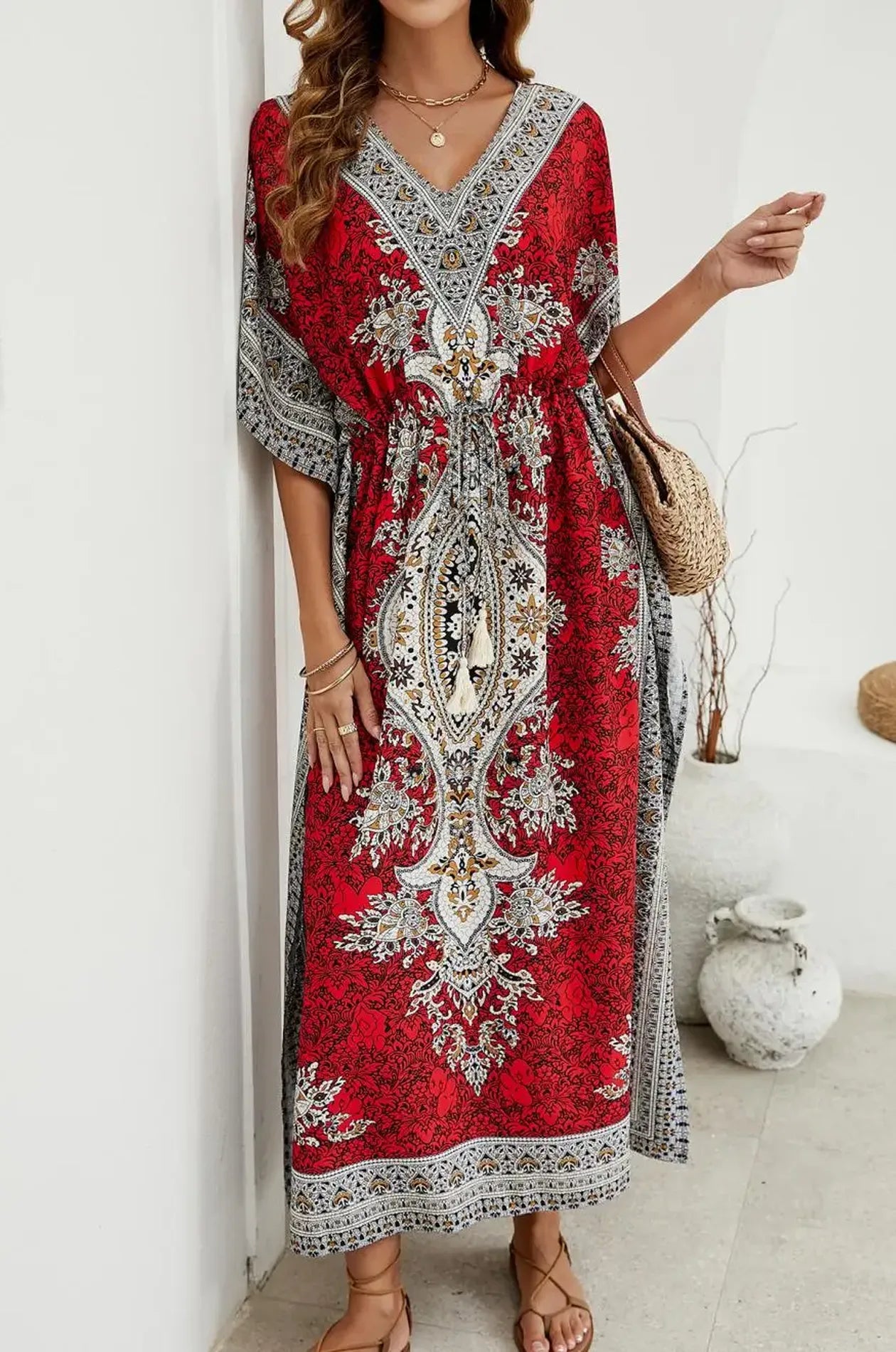 Crimson mandala kaftan with tassel waist tie leaning against white wall