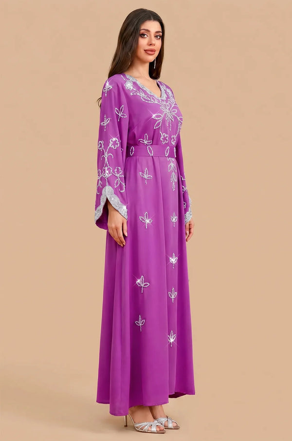 Side profile of the Maya Magenta Kaftan showing the fluid fabric drape and silver floral accents.