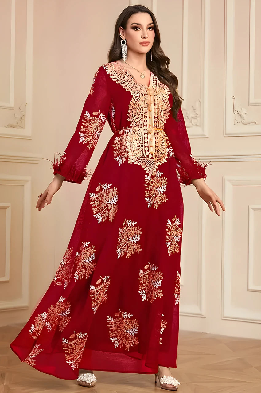 Lifestyle shot showing the flowing maxi silhouette of the Mhaya garnet feather-sleeve kaftan.