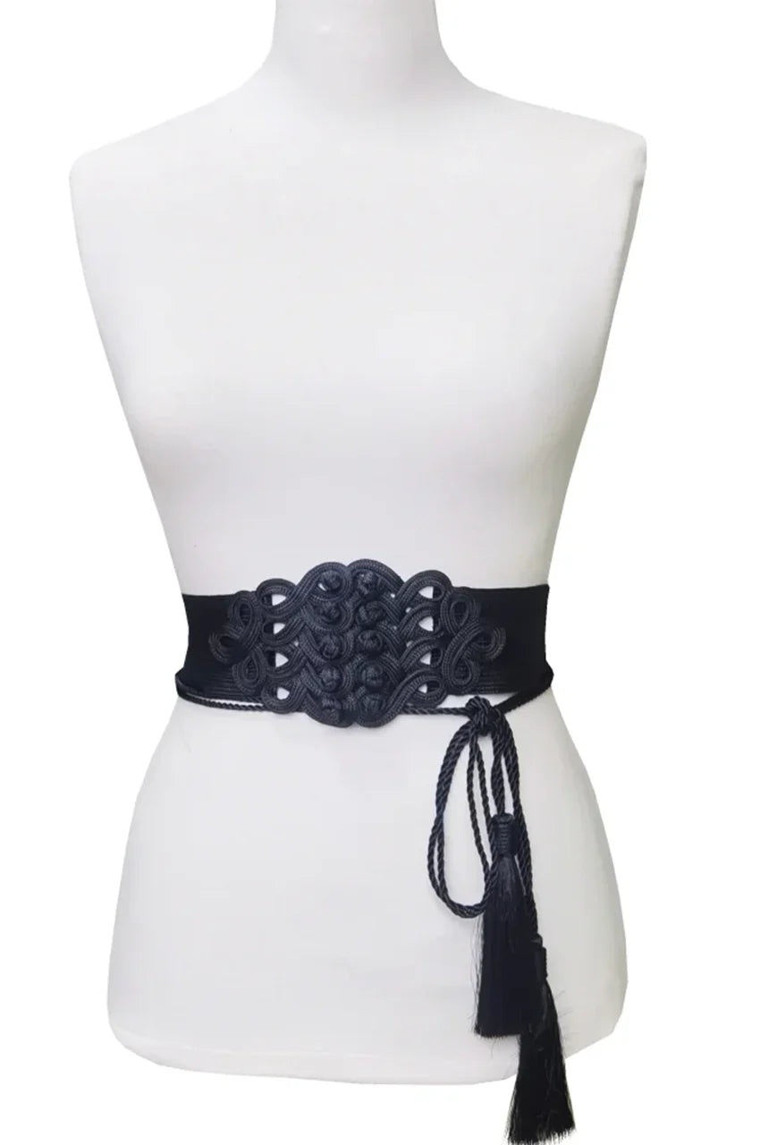Mannequin wearing wide black embroidered cord belt over a white dress to show fit.