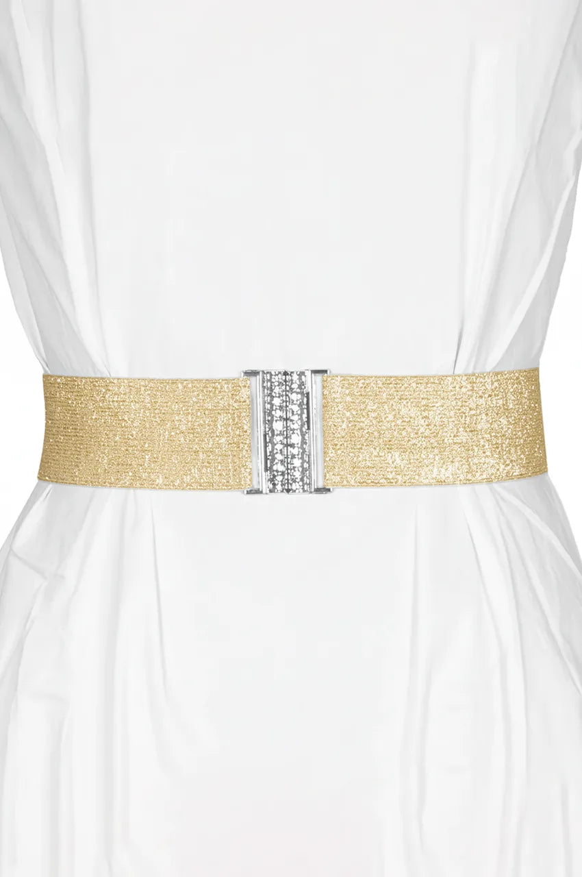 Woman wearing a wide gold elastic cinch belt over a white dress to define the waistline.