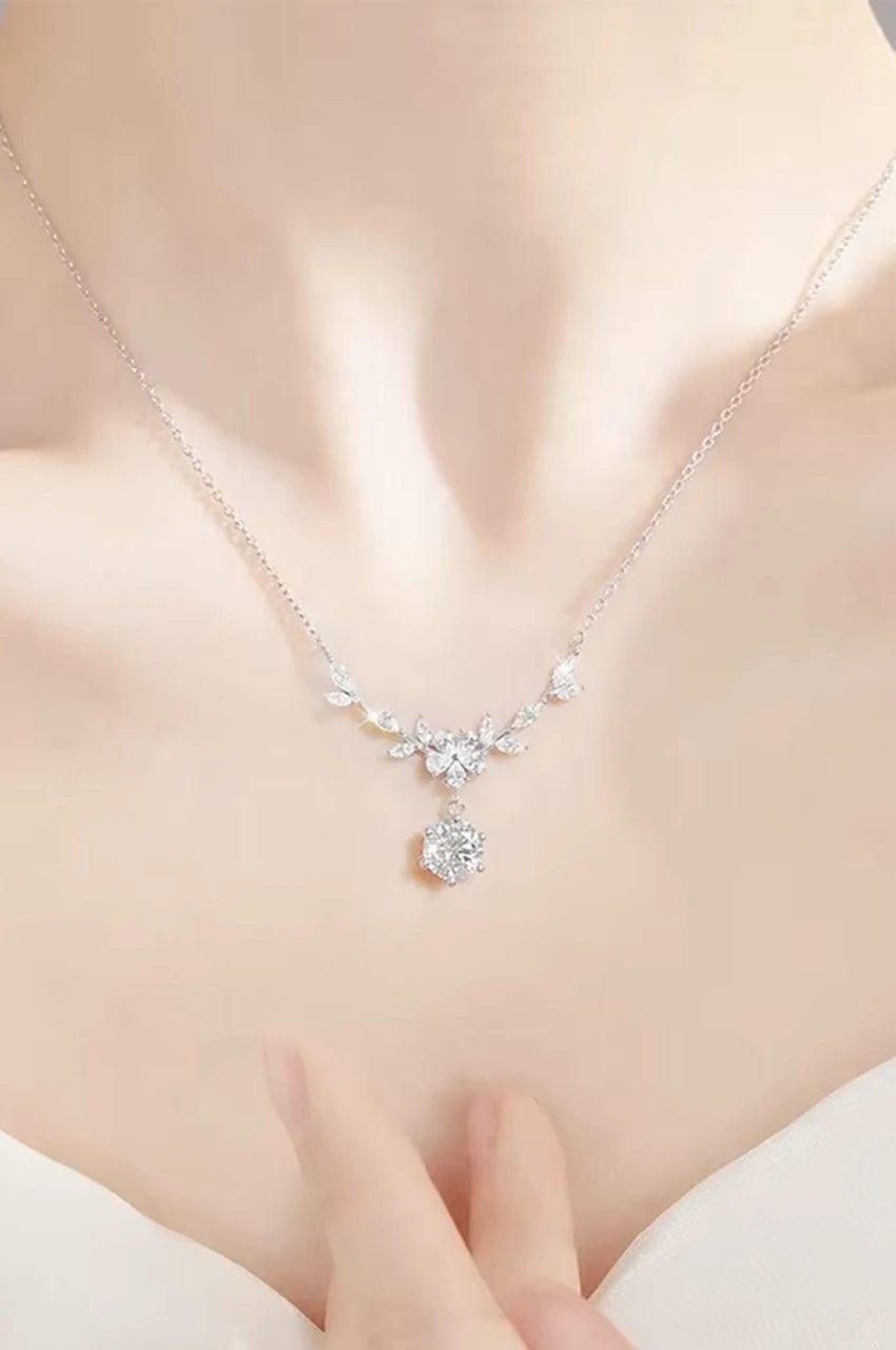 Model wearing silver floral drop necklace paired with wedding attire