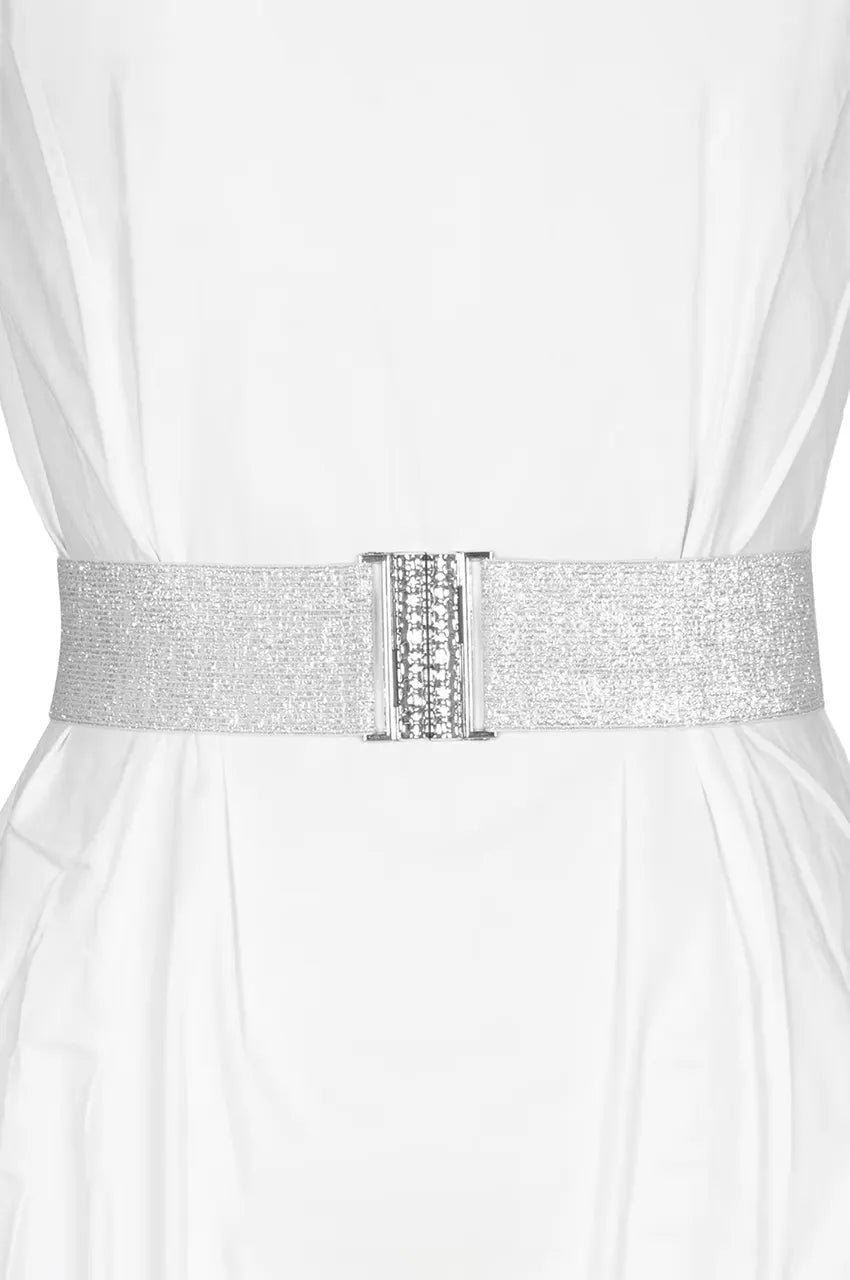 Woman wearing a wide silver elastic waist belt with crystal buckle over a white kaftan dress.