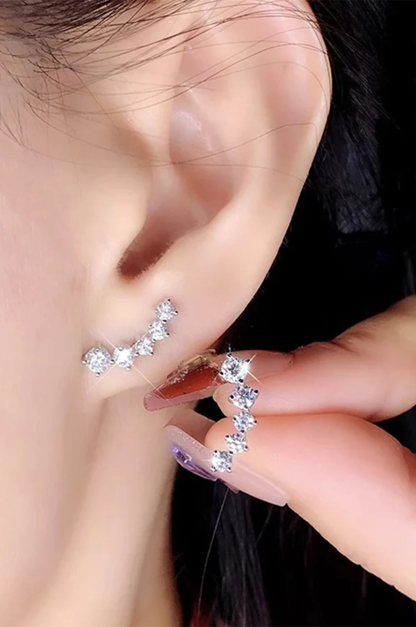 Close up of woman wearing silver crystal ear climbers showing fit along the earlobe.