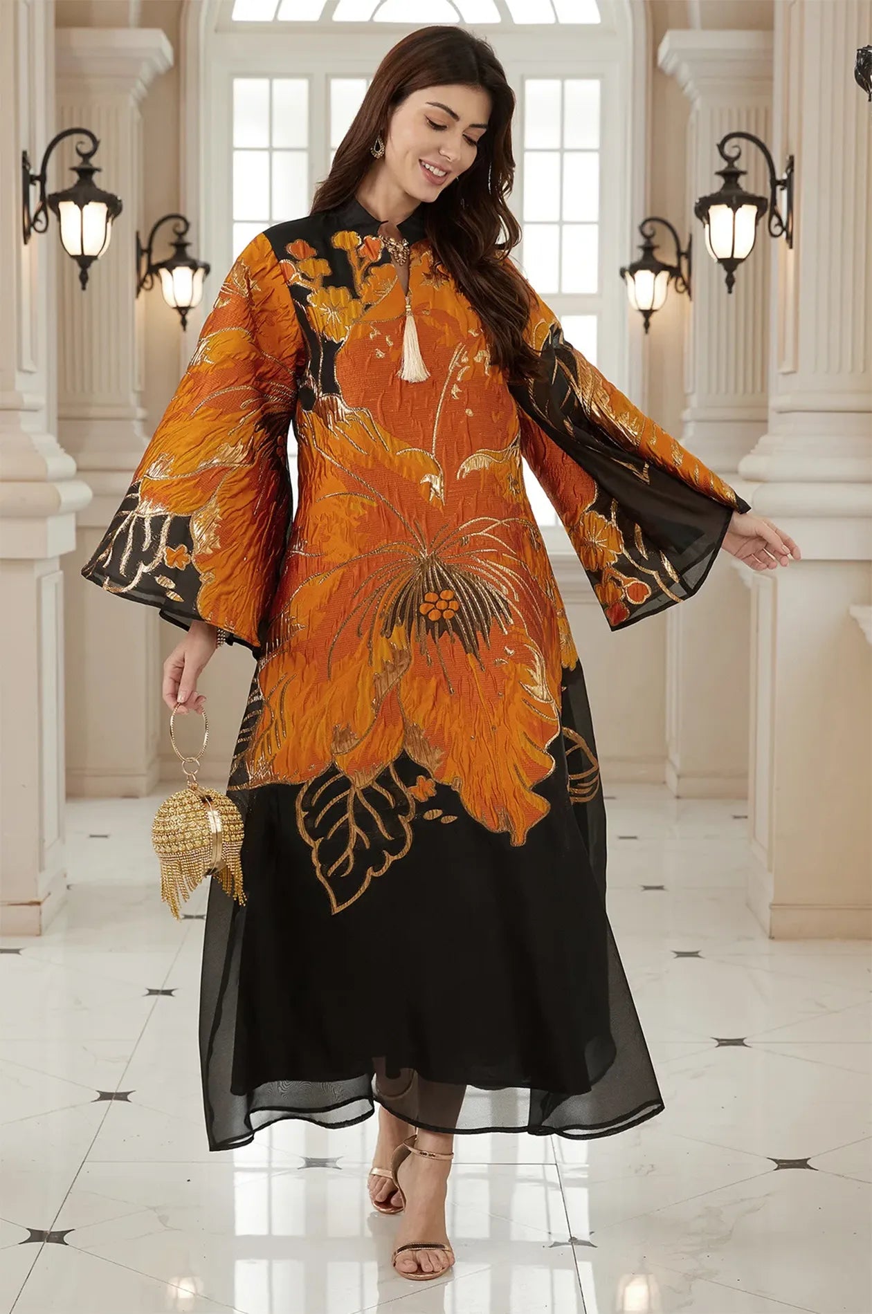 Dynamic movement shot of the Naeli Orange Flowy Kaftan showing the elegant drape of the gold-embellished fabric.