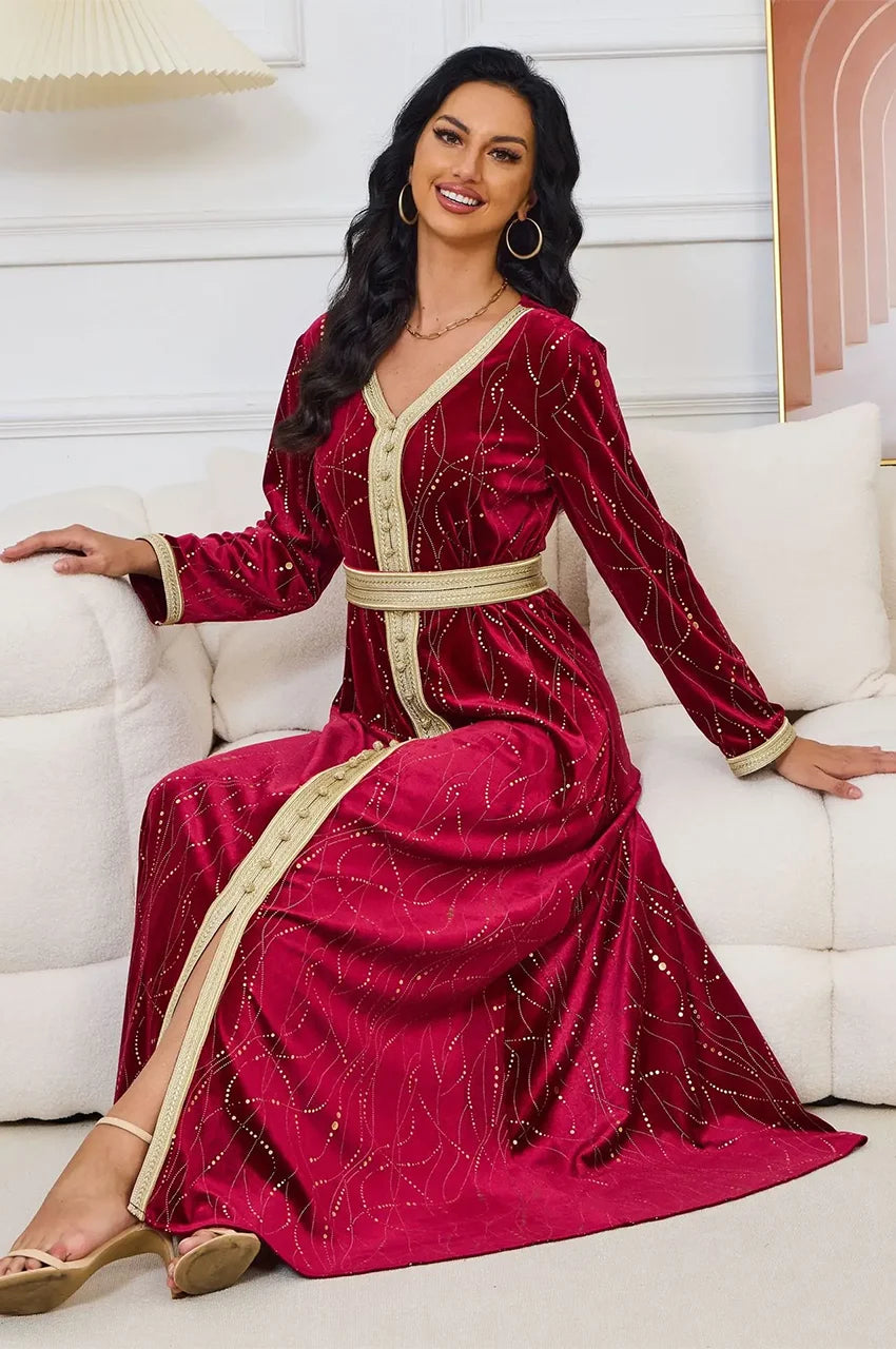 Model sitting in Naeva burgundy kaftan displaying gold central trim details.