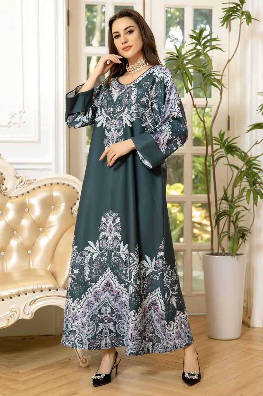 Model posing in Narya emerald kaftan dress showing fabric movement and silver motif contrast.