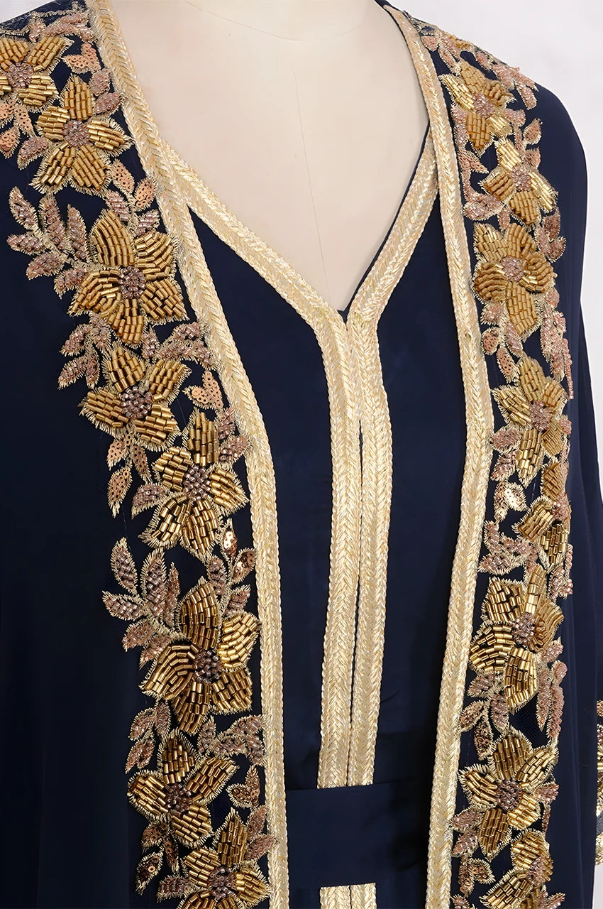 Close-up of handcrafted gold floral beadwork and Sfifa trimmings on a navy blue and gold kaftan.