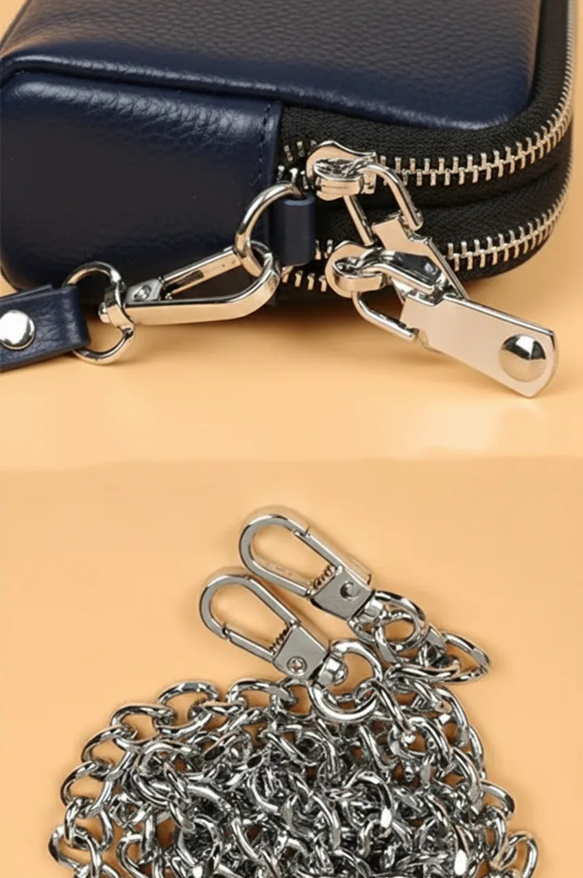 Close-up detail showing polished silver zipper pulls and metal clasps on the navy blue bag.