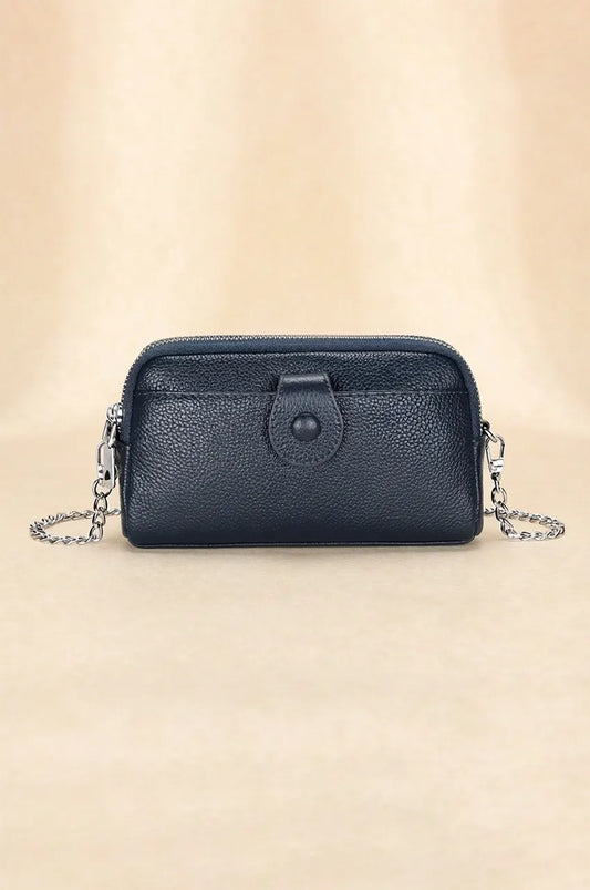 Front view of navy blue pebbled leather crossbody phone bag with snap pocket and silver chain strap.