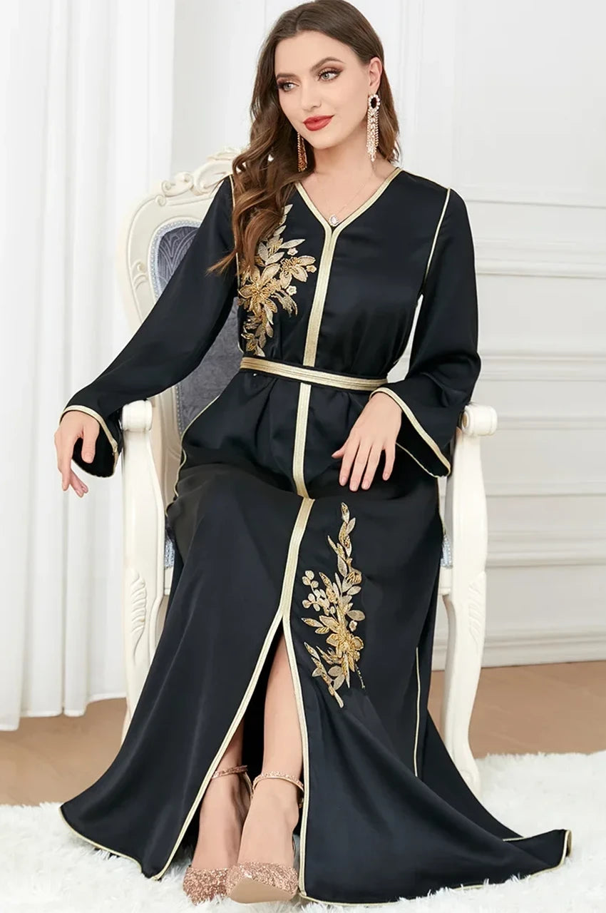 Model seated wearing black and gold Naylah Moroccan kaftan