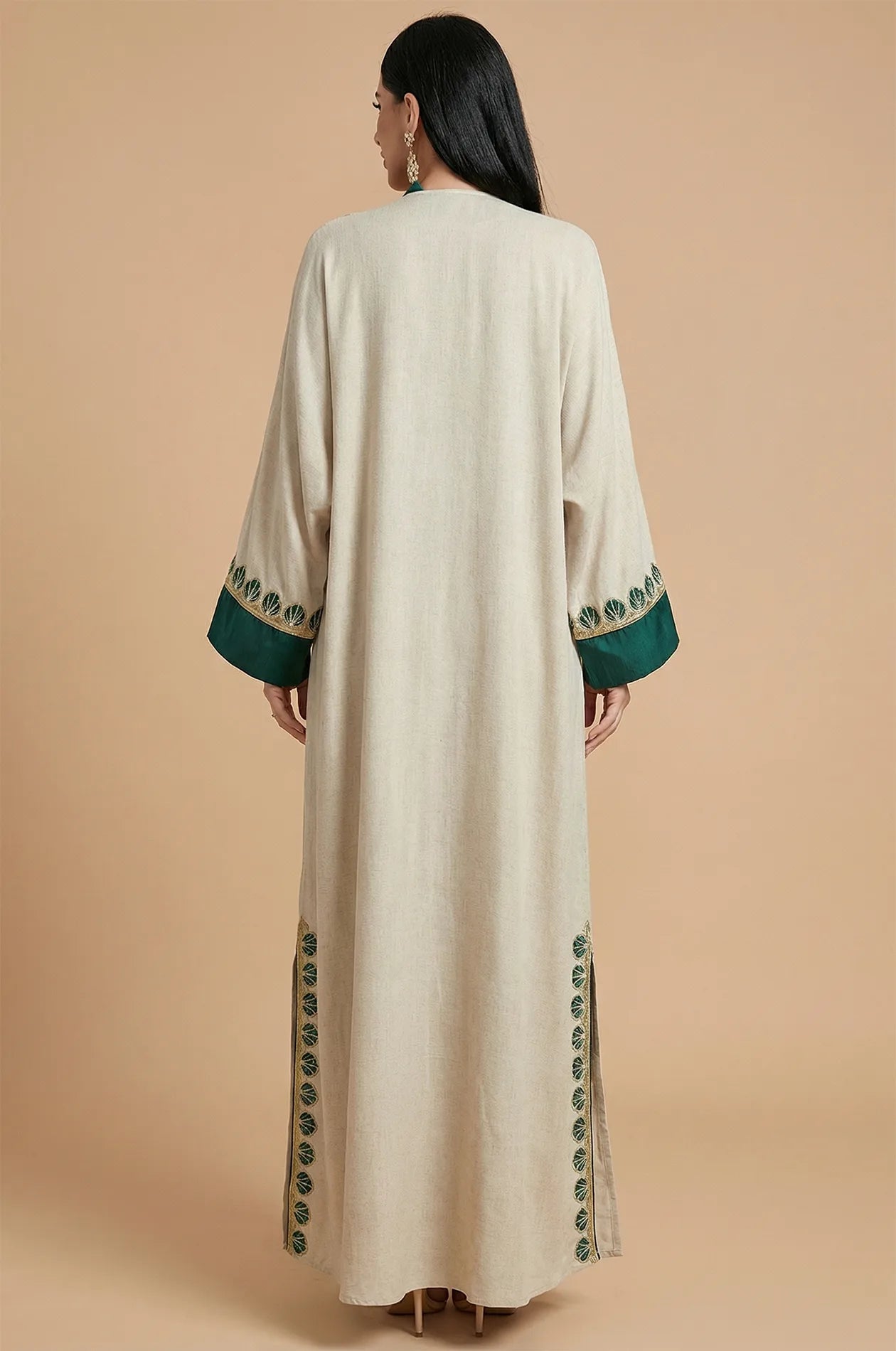 Back view of the Ameline beige kaftan dress showing the elegant silhouette and green embroidered patterns on the hem and cuffs.