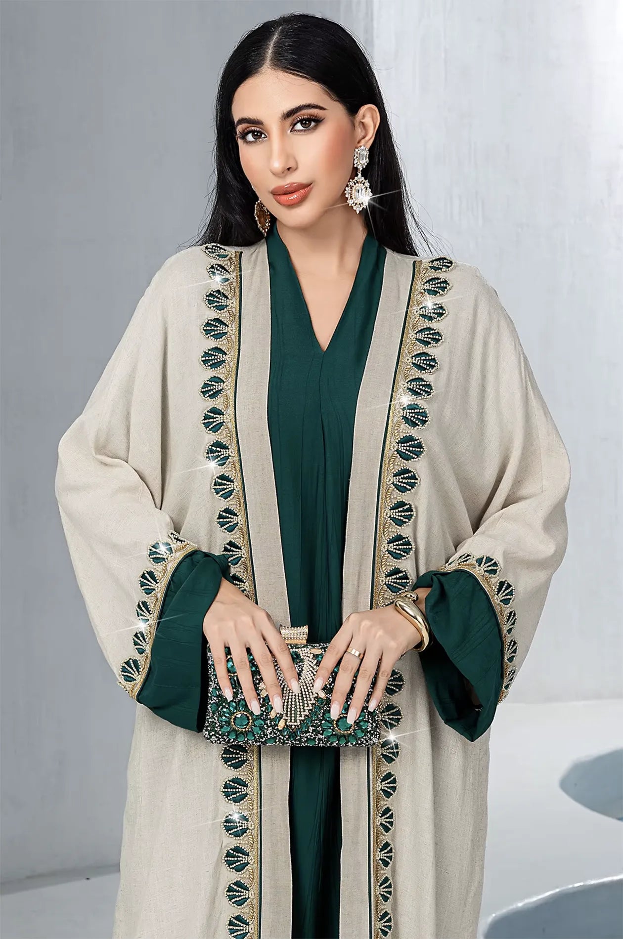 Close-up of the intricate gold and green beadwork and artisanal scallop embroidery on the front border of the Ameline beige kaftan.