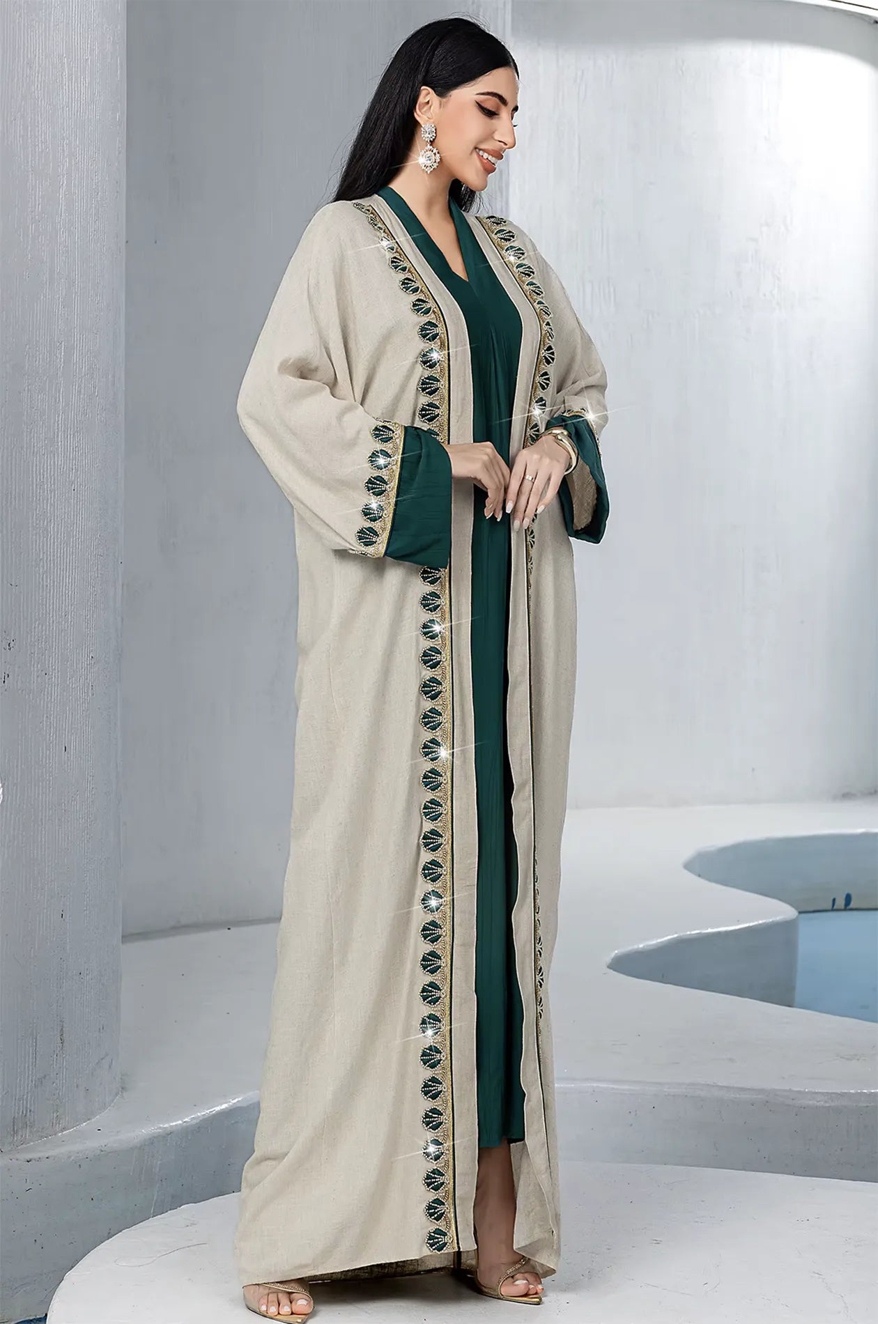 Elegant side view of the Ameline beige kaftan dress highlighting the side slit and the rich texture of the emerald green inner dress.