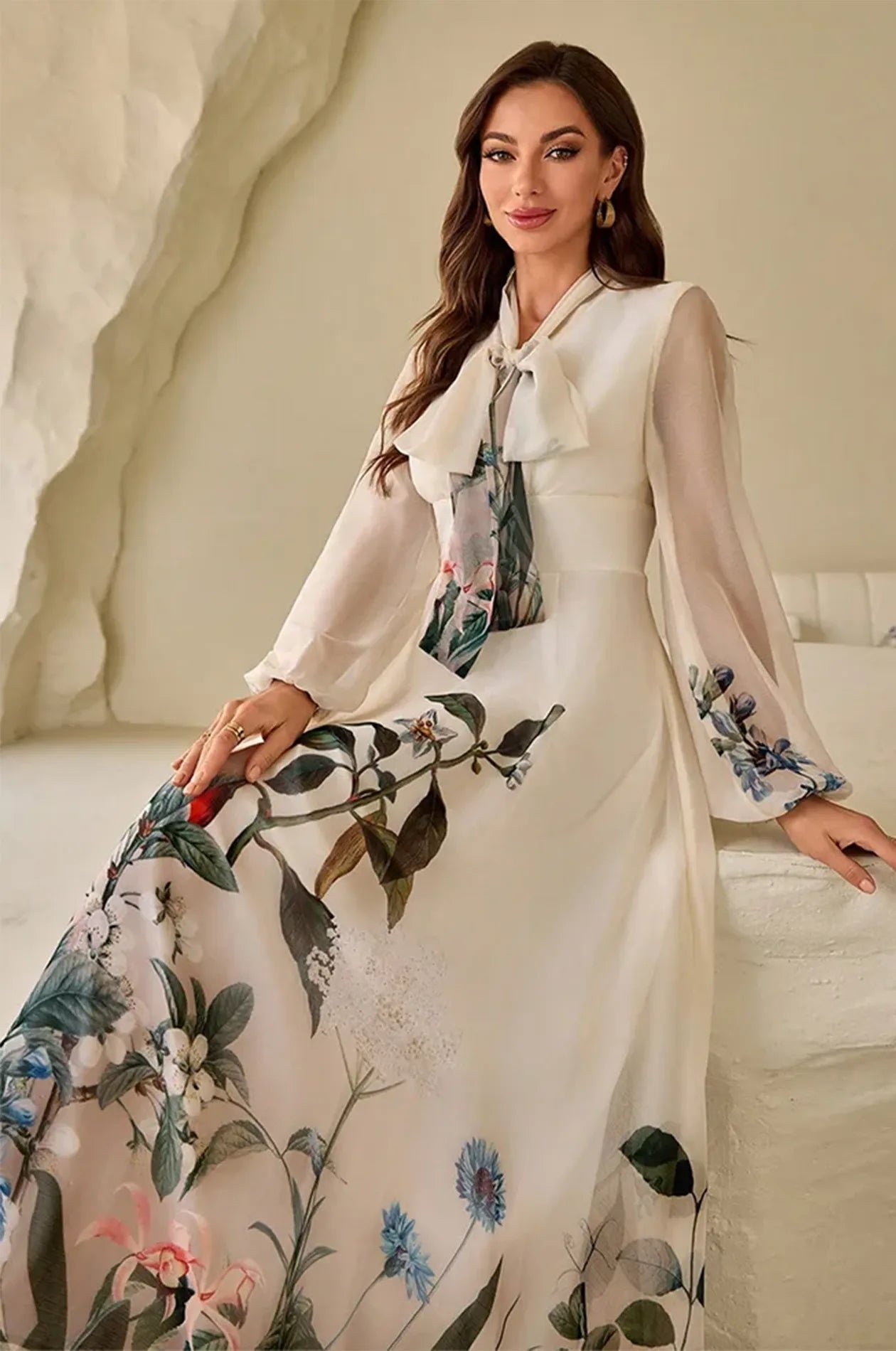 Model sitting in the Arina cream kaftan highlighting the botanical print detail.
