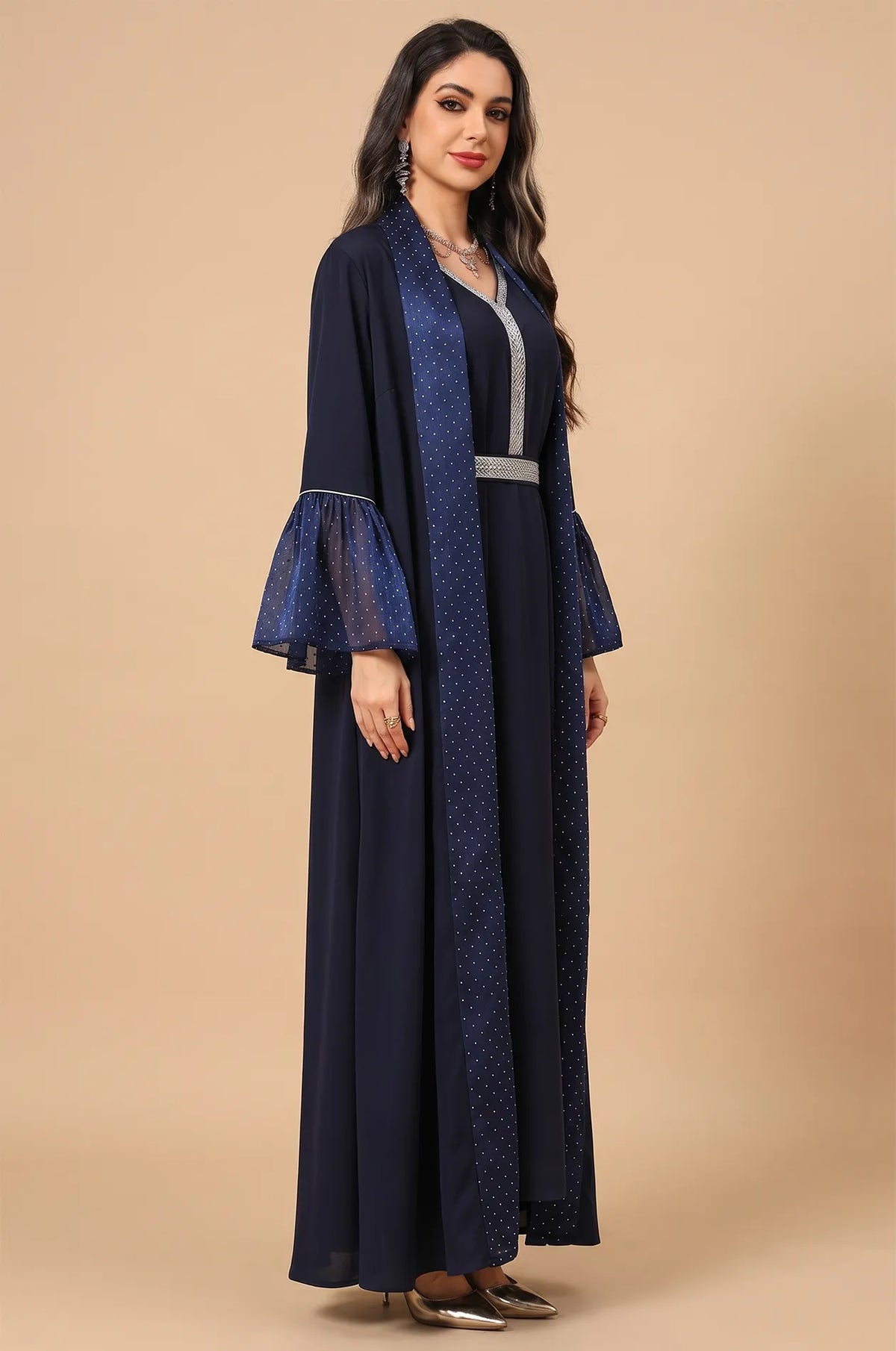 Angled full-length shot of the Auris Blue Kaftan by Naylara featuring silver rhinestone accents and ruffled sleeves.