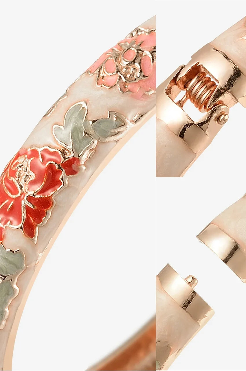 Extreme close up of enamel beige texture and gold outlines on floral bracelet.