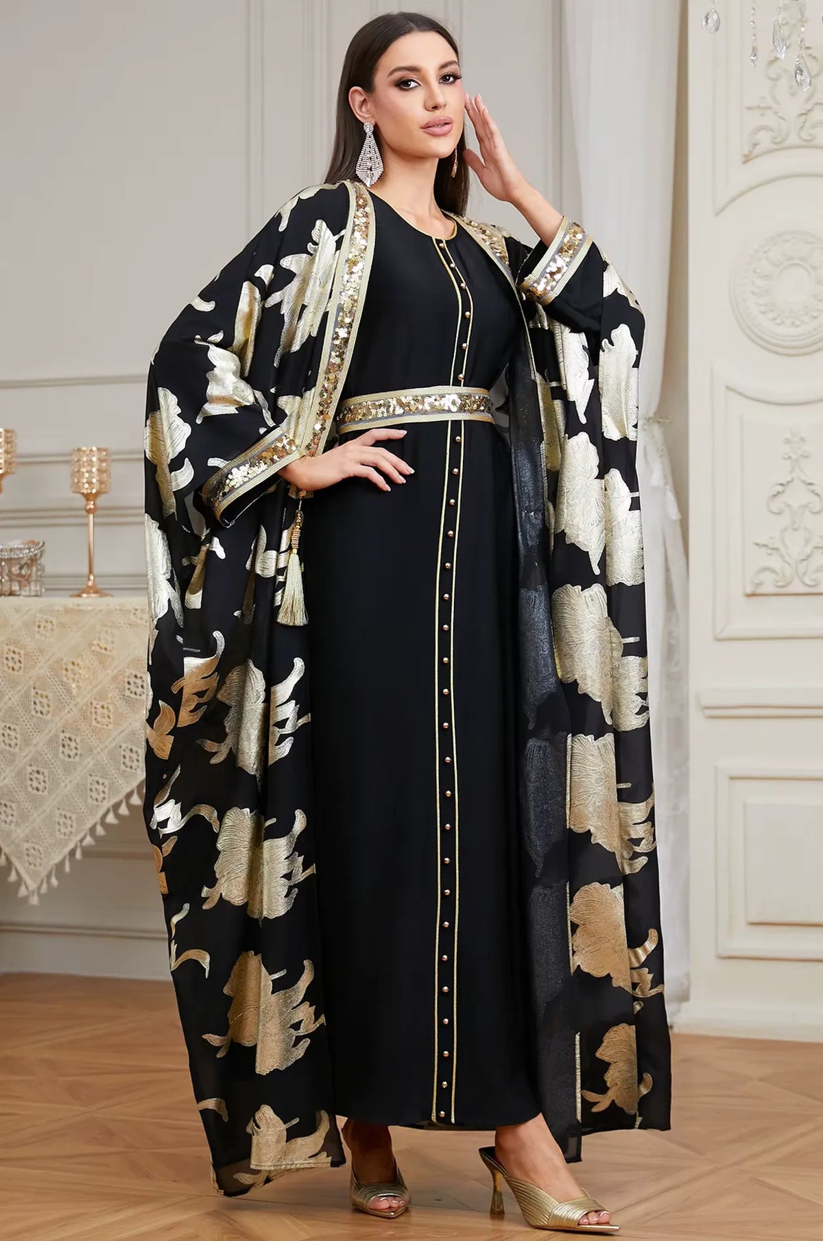 A stunning front pose of the Naylara Black Puppis kaftan luxe featuring gold floral motifs and a hand-placed sequin belt.