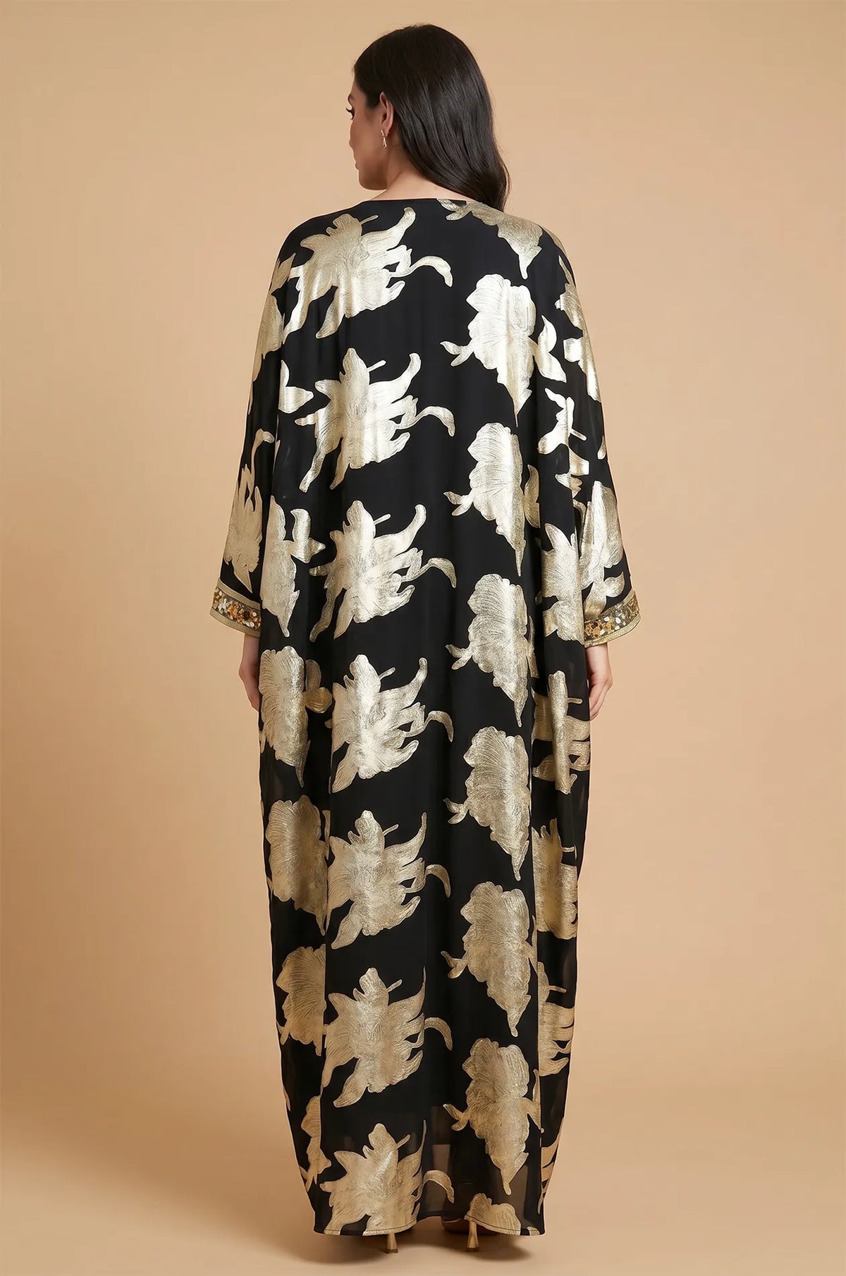 Full back view of the Black Puppis kaftan luxe showing the intricate gold floral patterns across the cape-style back.