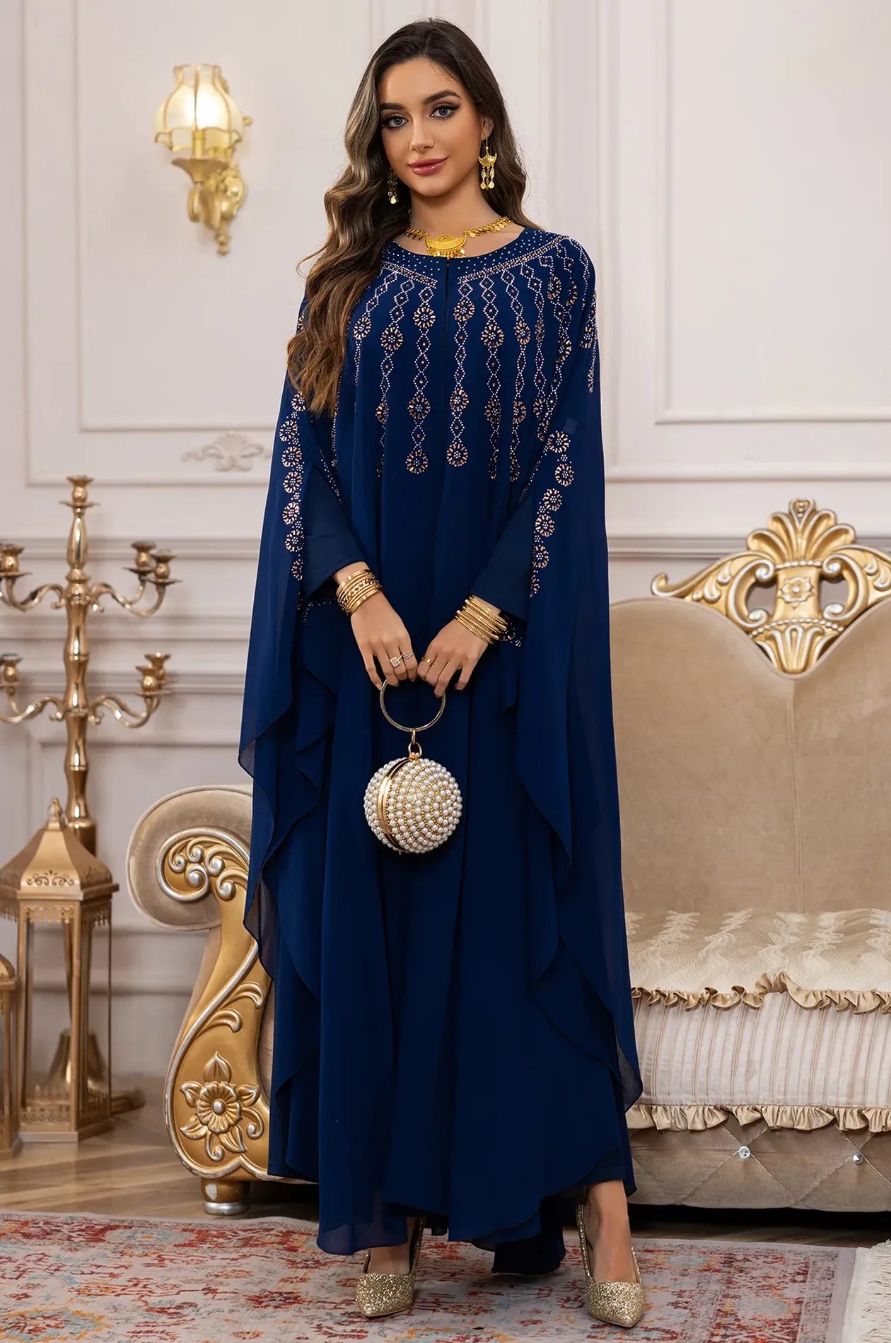Full-body shot of the Blue Cassia Rhinestone Kaftan styled with a luxury pearl evening bag.