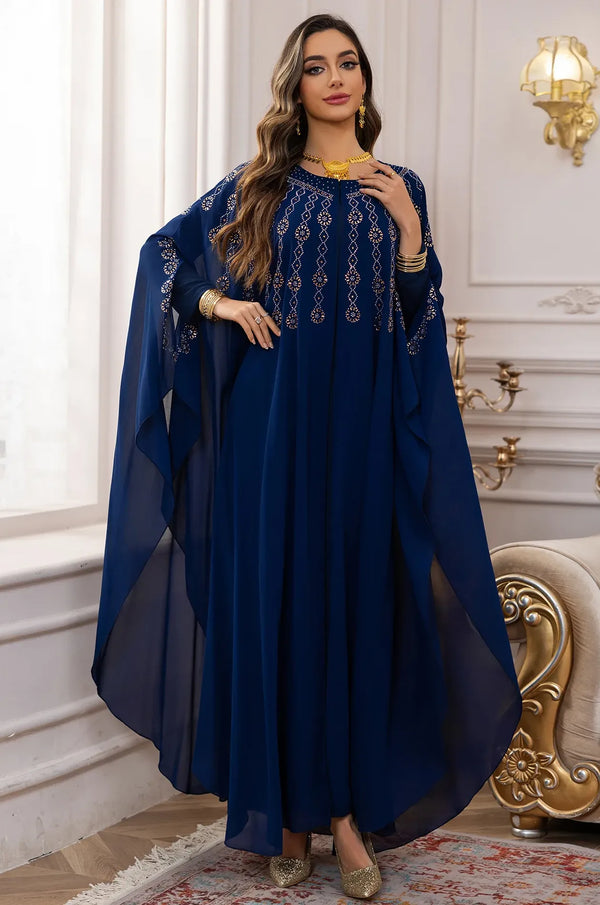 An elegant posed shot of the Navy Blue Cassia Rhinestone Kaftan in a luxury interior setting.