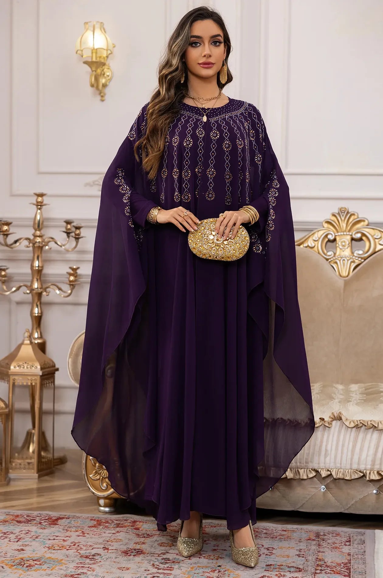 Front view of the Naylara Cassia Purple Rhinestone Kaftan styled with a gold floral clutch.