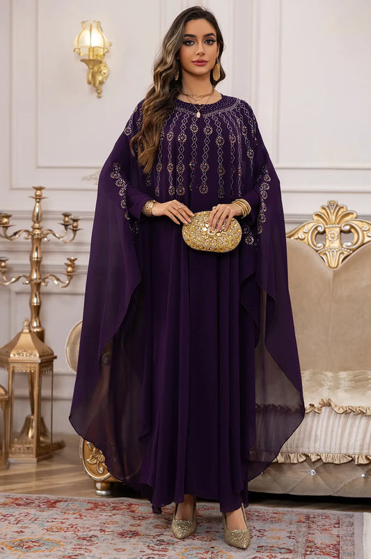 Front view of the Naylara Cassia Purple Rhinestone Kaftan styled with a gold floral clutch.