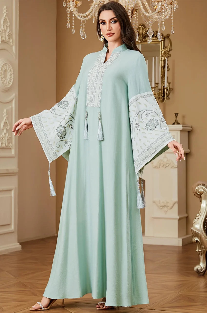 Full-length view of the Cyan Nairi cotton kaftan maxi in a luxury interior, showcasing white embroidery and a flowing silhouette