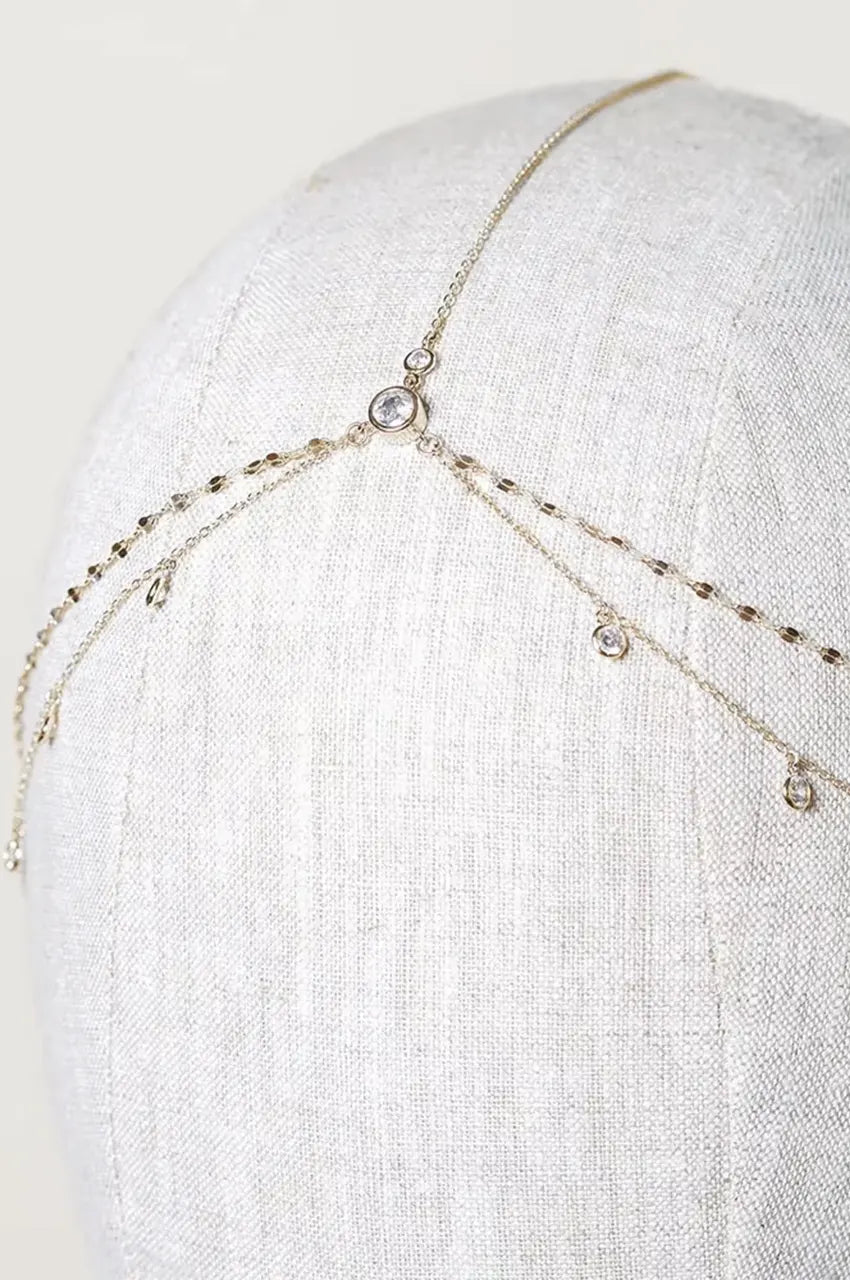 Close-up of the gold layered head chain with rhinestones on a mannequin head.