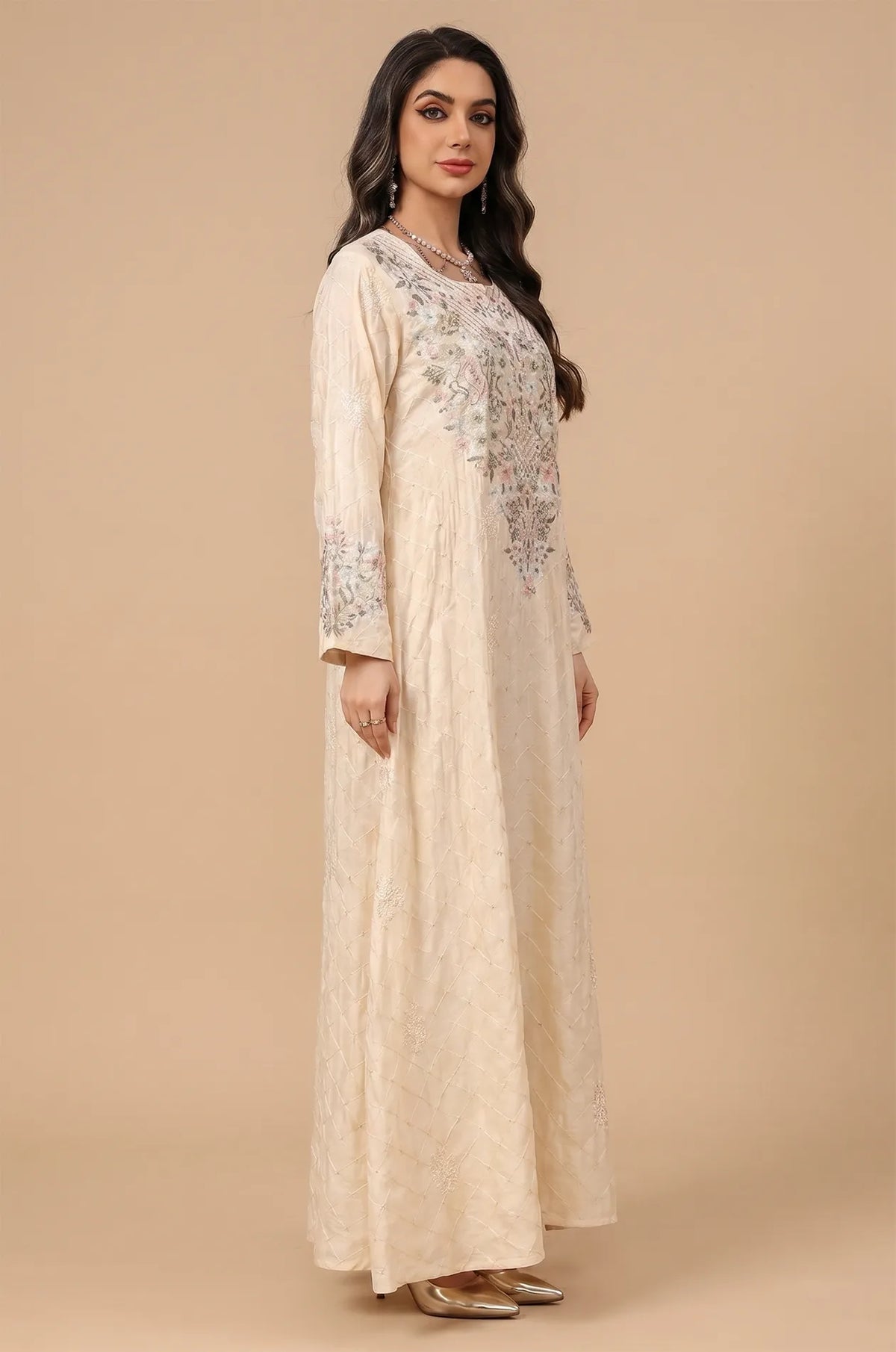 Side profile of a model wearing the beige Equis modest kaftan with bell sleeves and floral patterns.