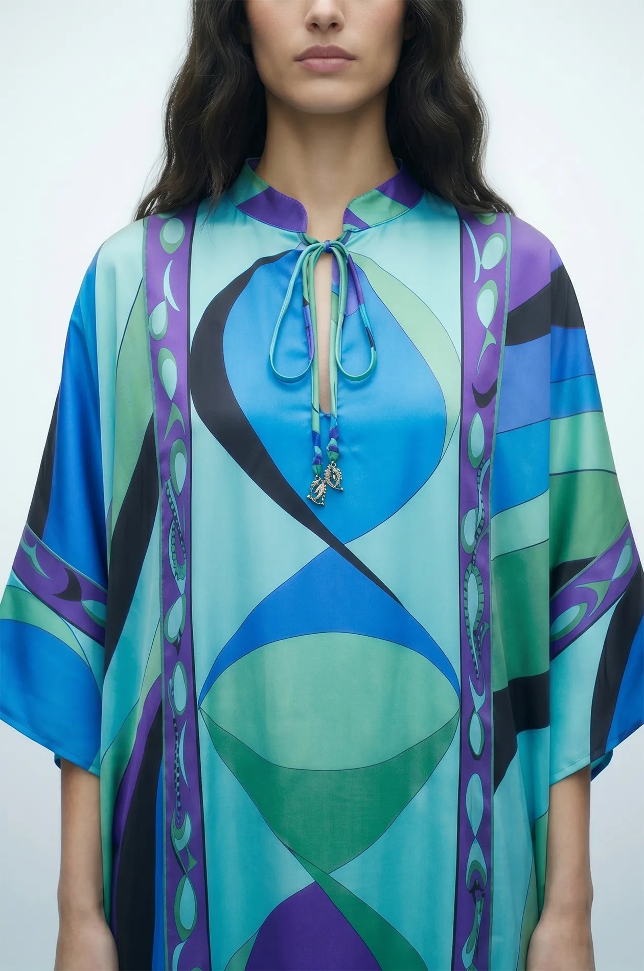 Close-up of Naylara Erica kaftan tassel tie neckline with rhinestone dolphin charms