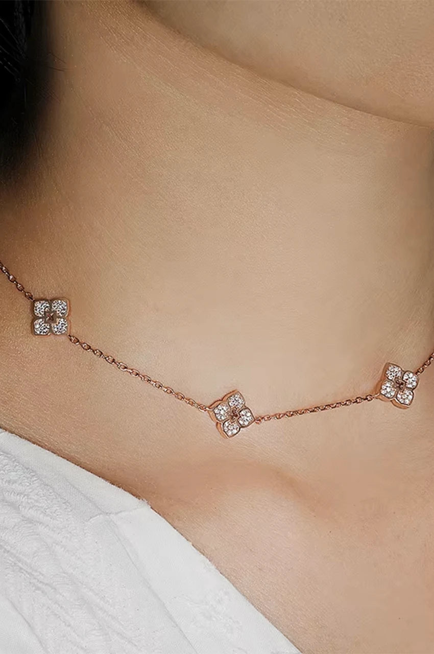 Close up of woman wearing lucky clover motif necklace on neck