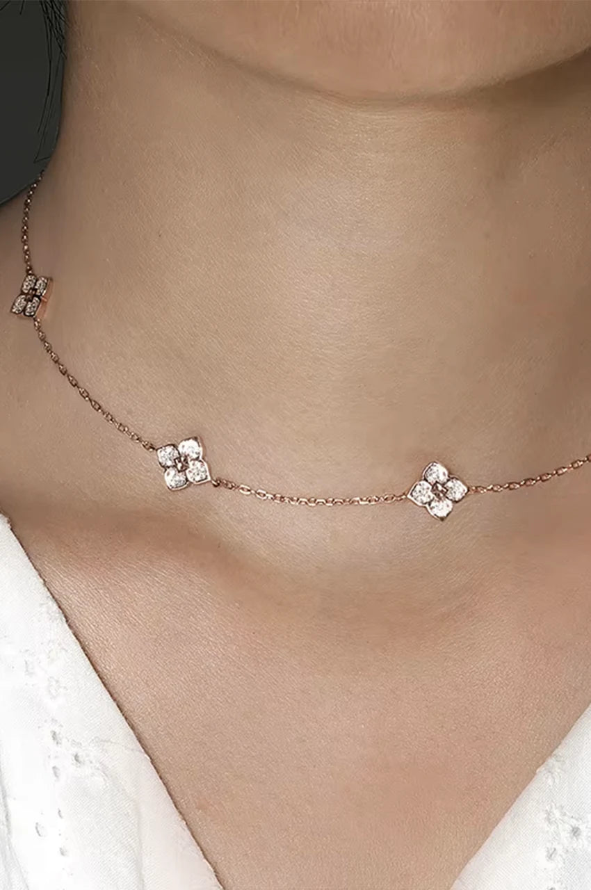 Model wearing dainty floral station necklace perfect for layering