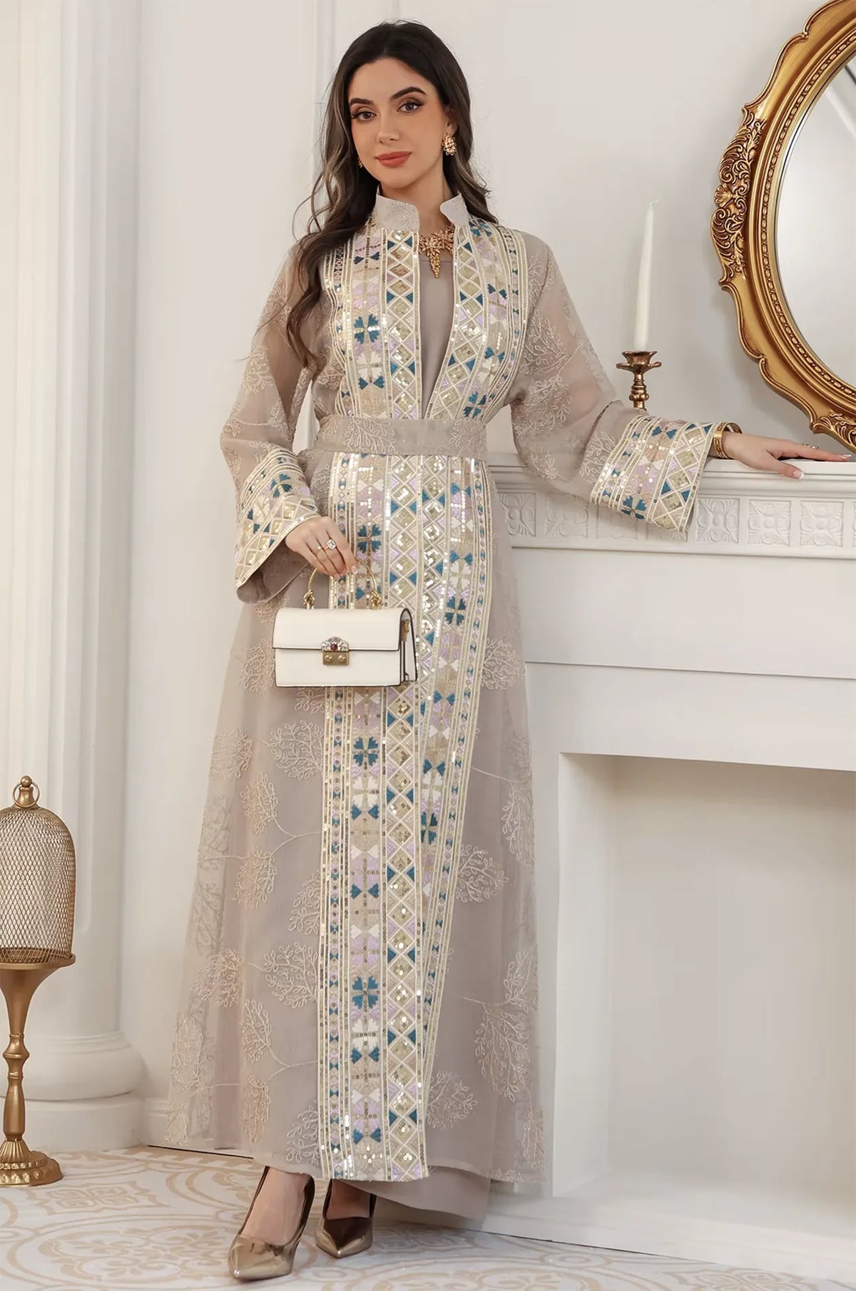 Modern styling of the apricot beige Gienah chic kaftan paired with a designer white handbag for an evening party.