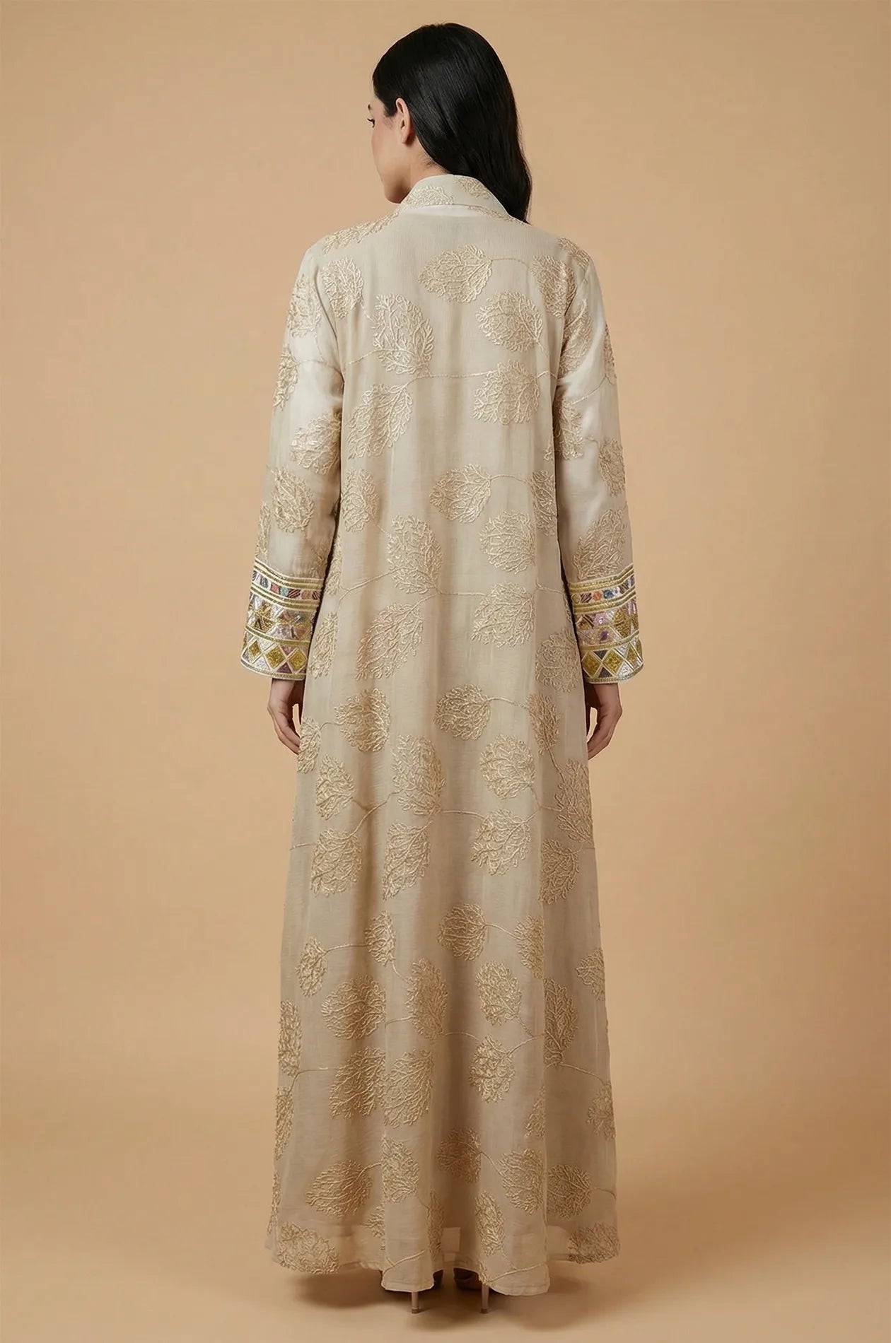 Back view of the apricot beige Gienah chic kaftan showing the elegant sheer fabric and intricate floral gold thread patterns.