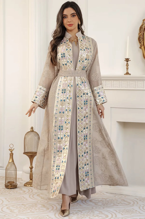 The Gienah chic kaftan in apricot beige styled for a formal event, featuring sheer sleeves and a majestic Mandarin collar.