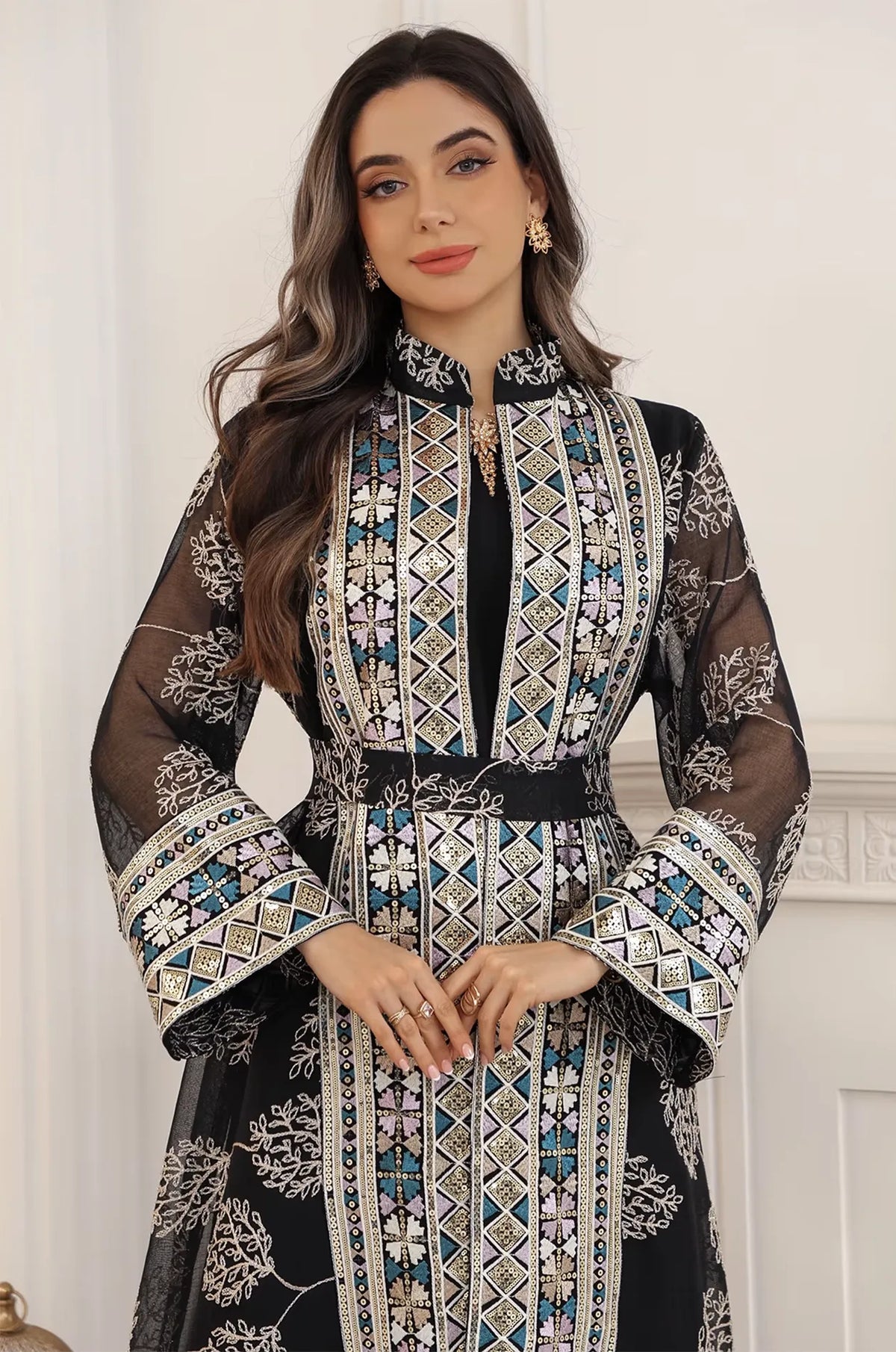 Close-up of the Gienah chic kaftan in black by Naylara, featuring intricate gold and teal geometric embroidery on the bodice.