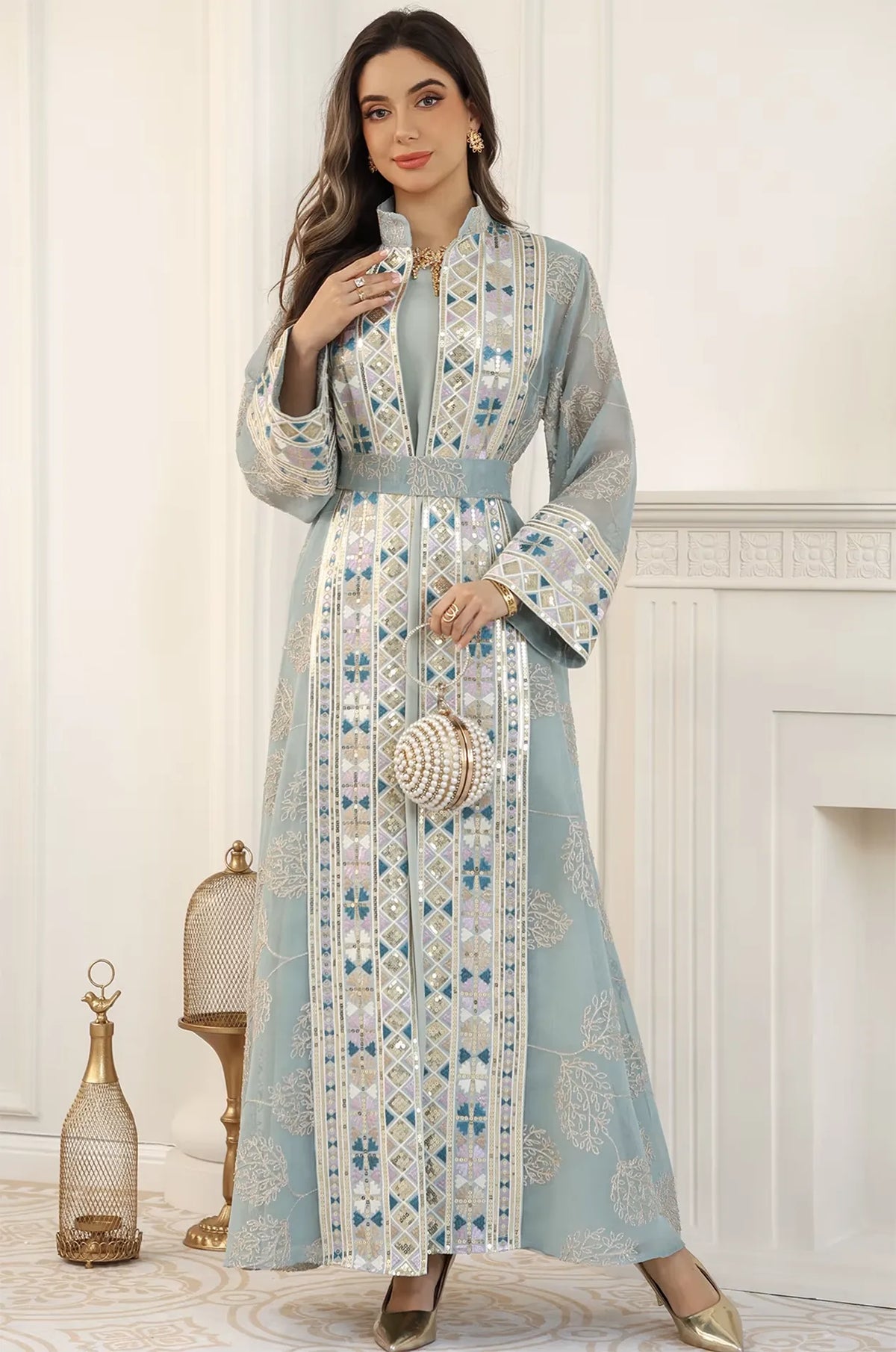 Full-body shot of the Gienah chic kaftan in light green styled with a pearl spherical clutch for a luxury evening look.