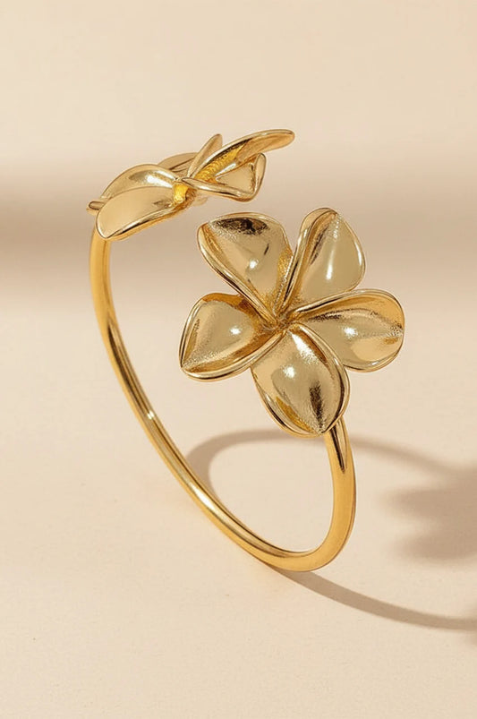 Gold open cuff bracelet with two large flower blossoms standing upright.
